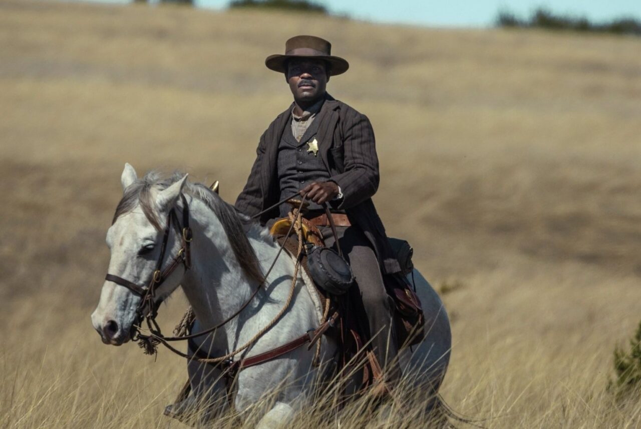 Bass Reeves riding a gray horse in the American countryside in the Lawmen Bass Reeves TV show